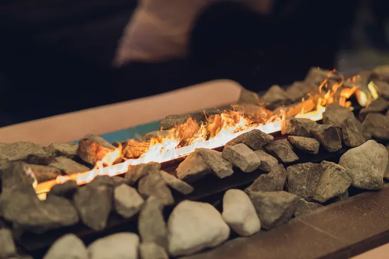 Long linear gas fire feature in stone surround
