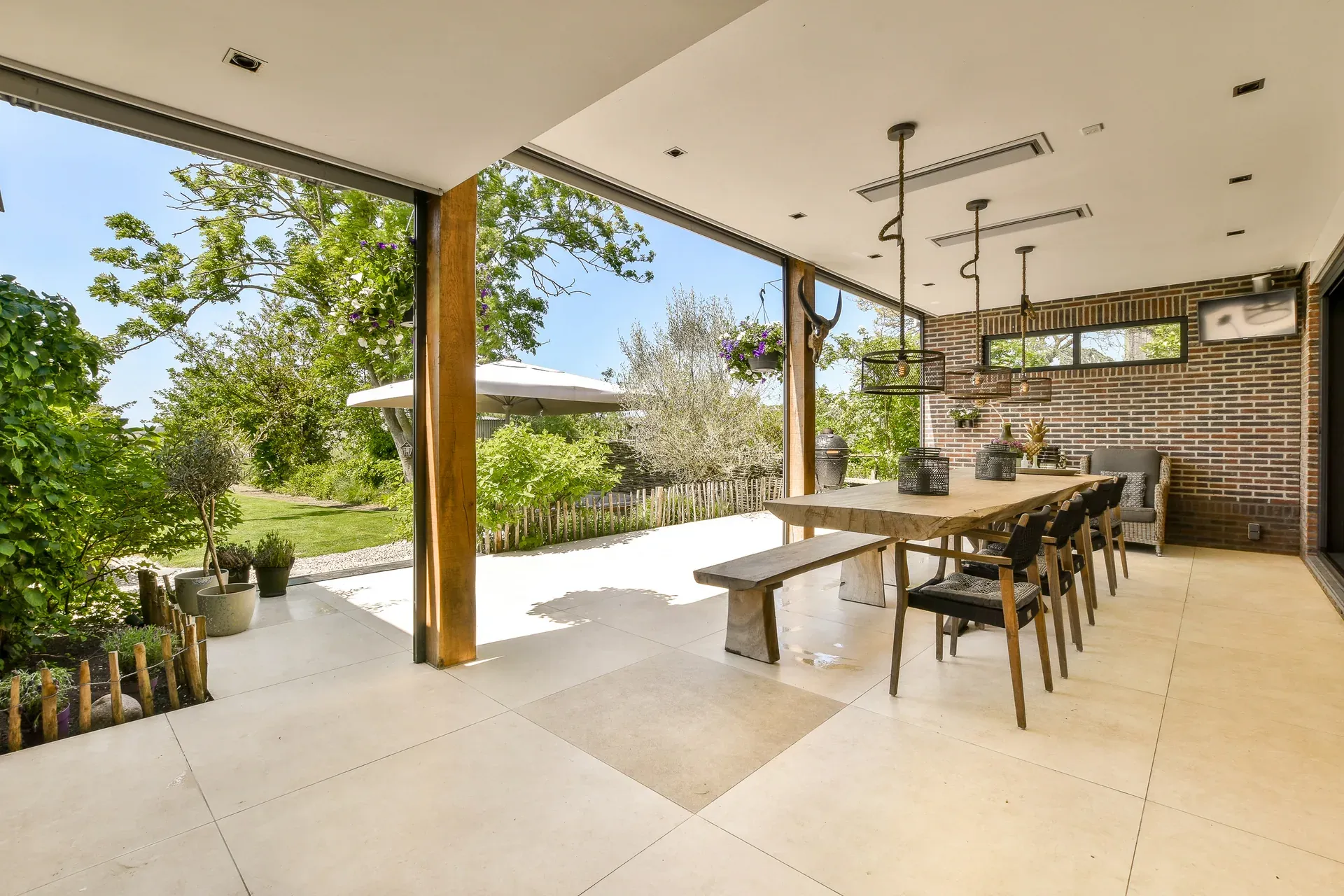 Outdoor kitchen with lit pergola at dusk